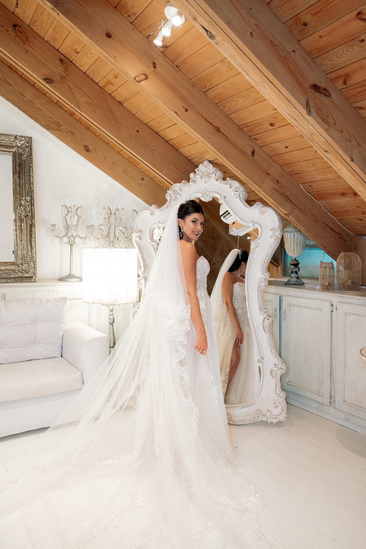 Makeup artist adding final touches to bride in lace wedding dress before ceremony